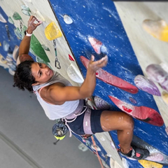 woman lead climbing in gym